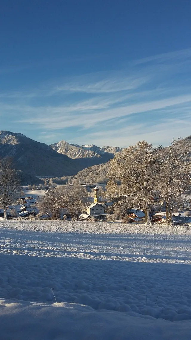 Verschneite Wiesen mit Blick auf die Berge
