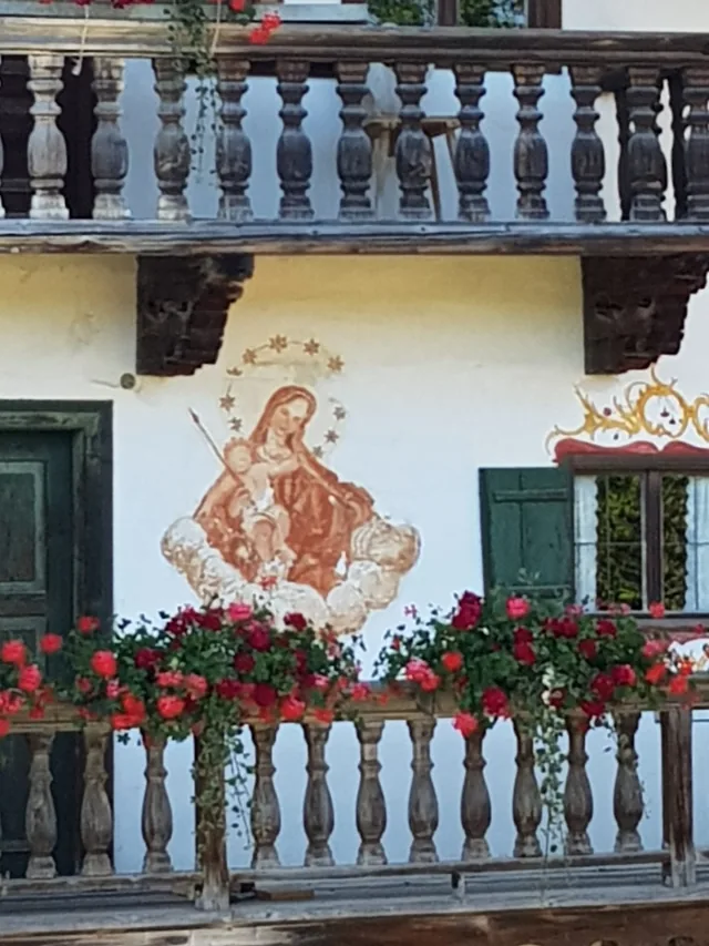 Lüftlmalerei und Balkon mit Blumen