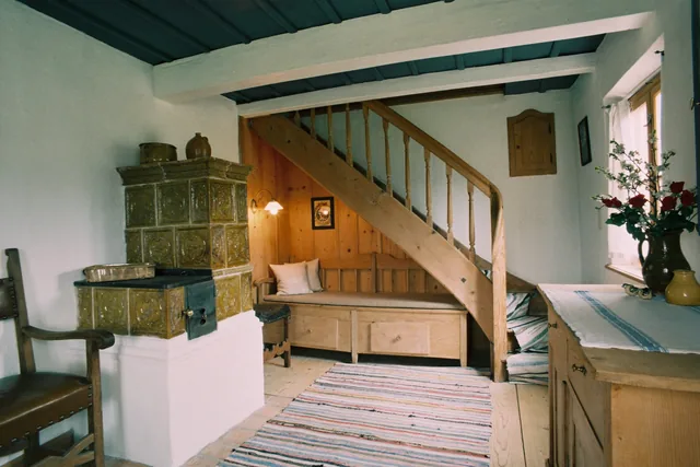Stube mit Kachelofen und Treppe
